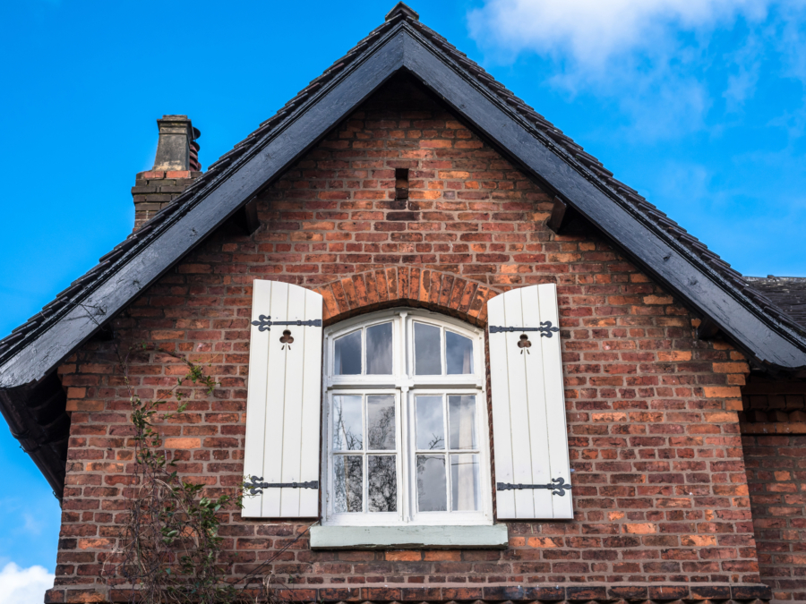 Red brick heritage property with white shutters, typical of a Grade II listed building, insured by Intelligent Insurance.